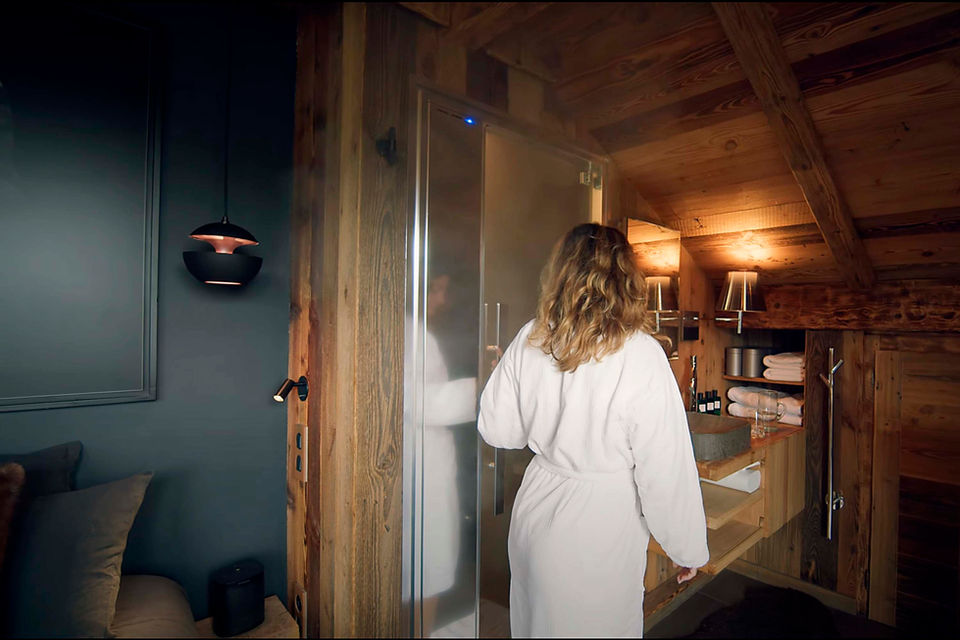 Femme entrant dans un hammam dans un chalet avec spa