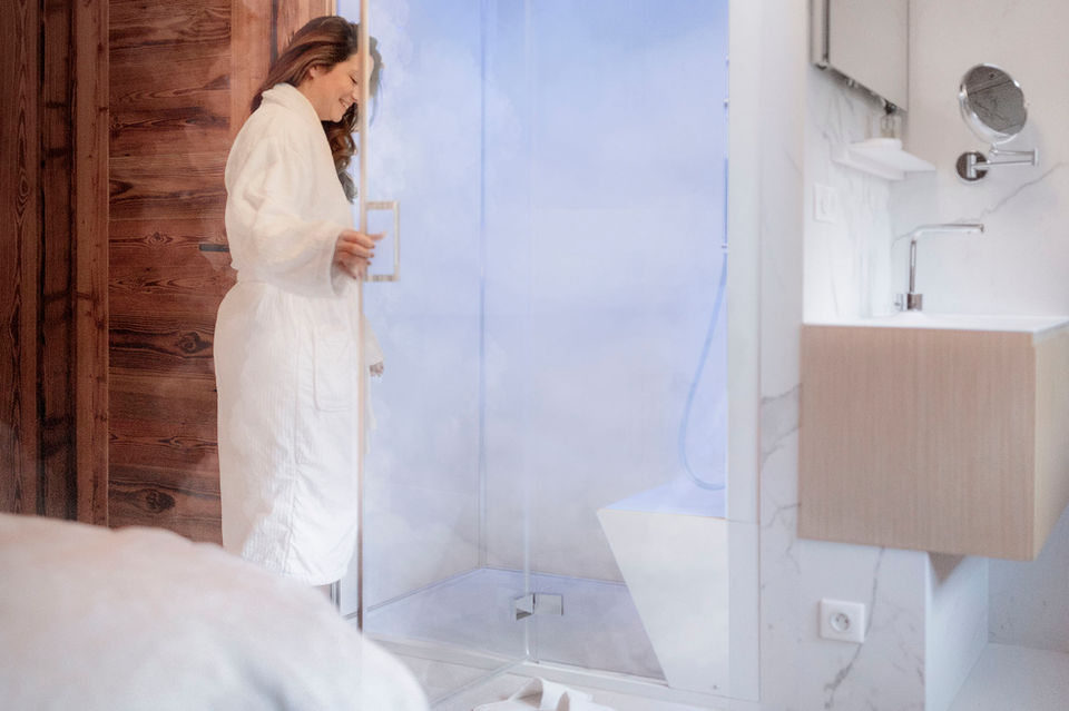 Femme entrant dans une douche hammam dans un chalet avec spa