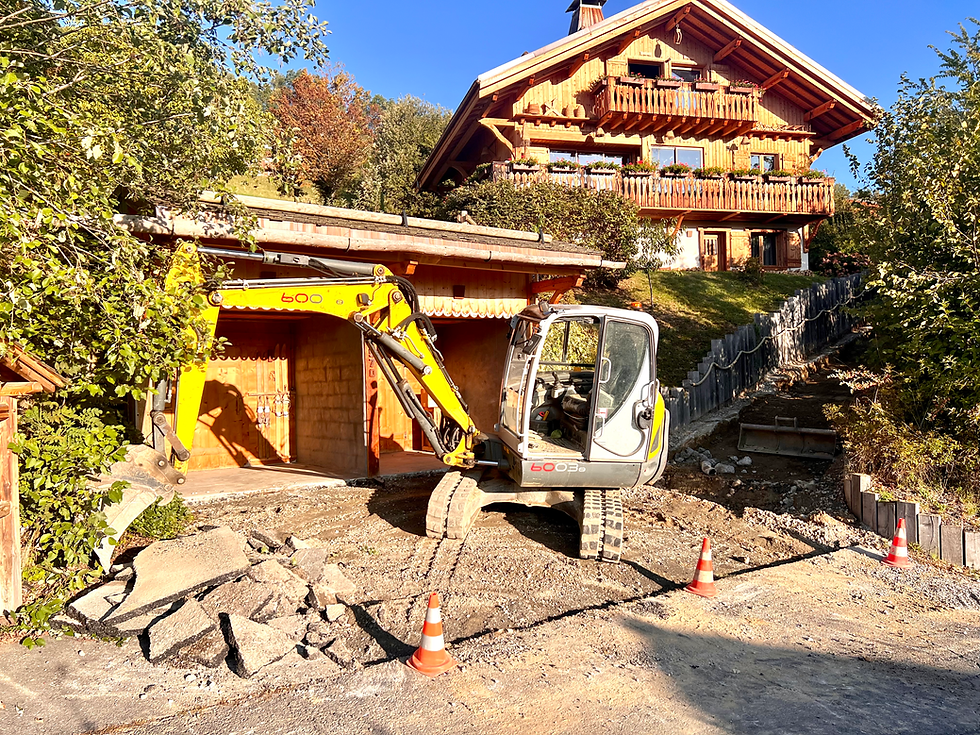 Une pelle mécanique devant un chalet de montagne