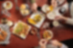 Friends passing plates at a dinner table.