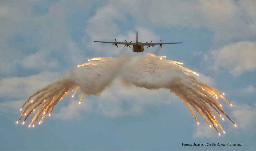 Aircraft releasing flares, forming a wing-like shape against a cloudy sky. Bright, fiery trails create a dynamic and dramatic scene.