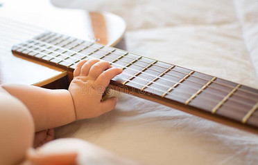 brazo-del-bebé-en-la-guitarra-104166415.