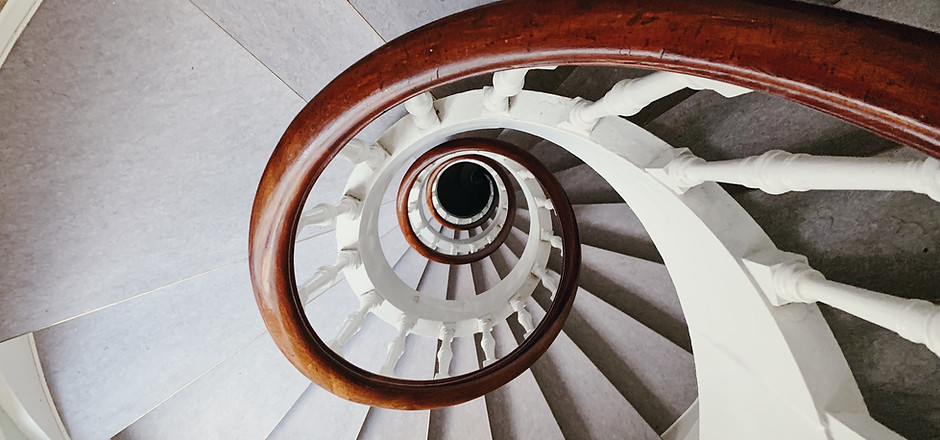 Escalier blanc en spirale avec rampe en bois