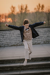 Springende jongen met de ondergaande zon op de kaai in Sint-Amands tijdens een lentefeest shoot door Souvenirs de Zoë Fotografie uit Puurs - Sint-Amands.