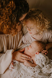 Newborn baby jongetje bij mama en grote zus op de schoot tijdens een hartverwarmende newborn lifestyle shoot bij Souvenirs de Zoë fotografie in Puurs en Sint-Amands.