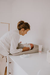Alledaagse gebeurtenissen tijdens een newborn lifestyle fotoshoot door Souvenirs de Zoë Fotografie in Antwerpen. Mama verschoont haar baby dochtertje.