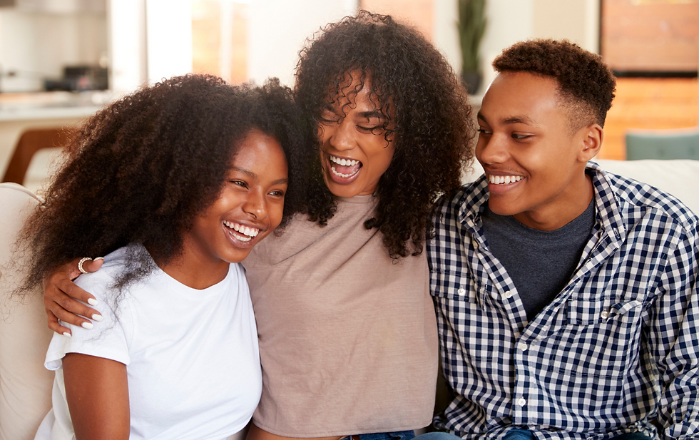 Adulto abraçando dois adolescentes com carinho e sorrisos, representando vínculo familiar e empatia emocional