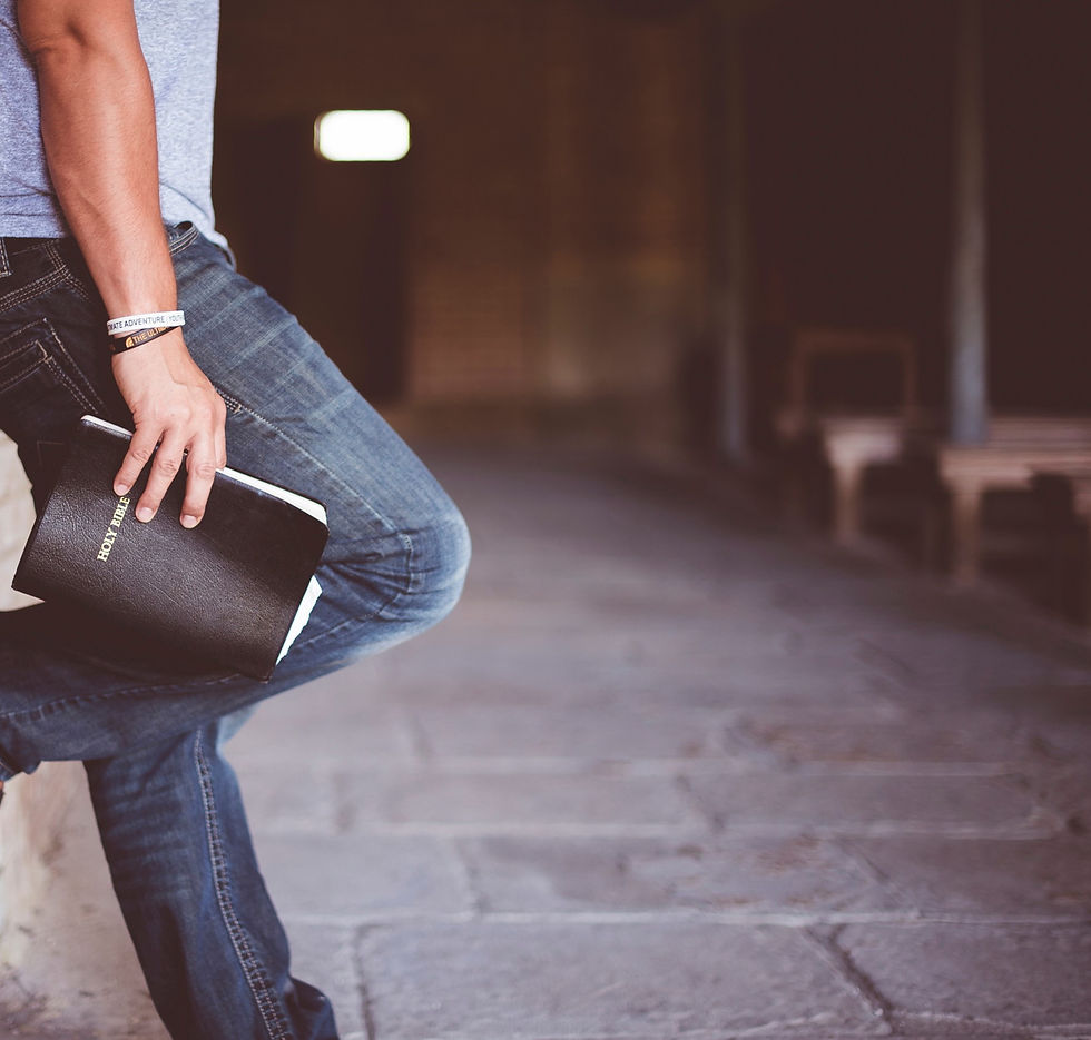man%20holding%20Holy%20Bible%20leaning%20on%20bricked%20wall_edited.jpg