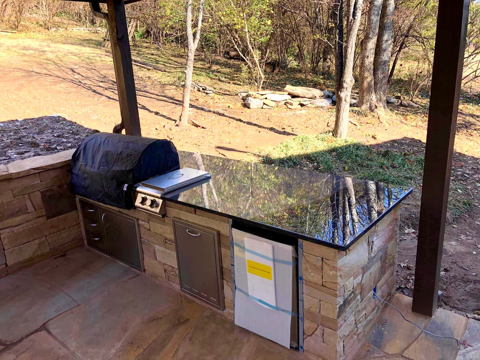 Outdoor kitchen in dark brown natural stone