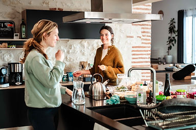 two people laughing and talking in a nice kitchen
