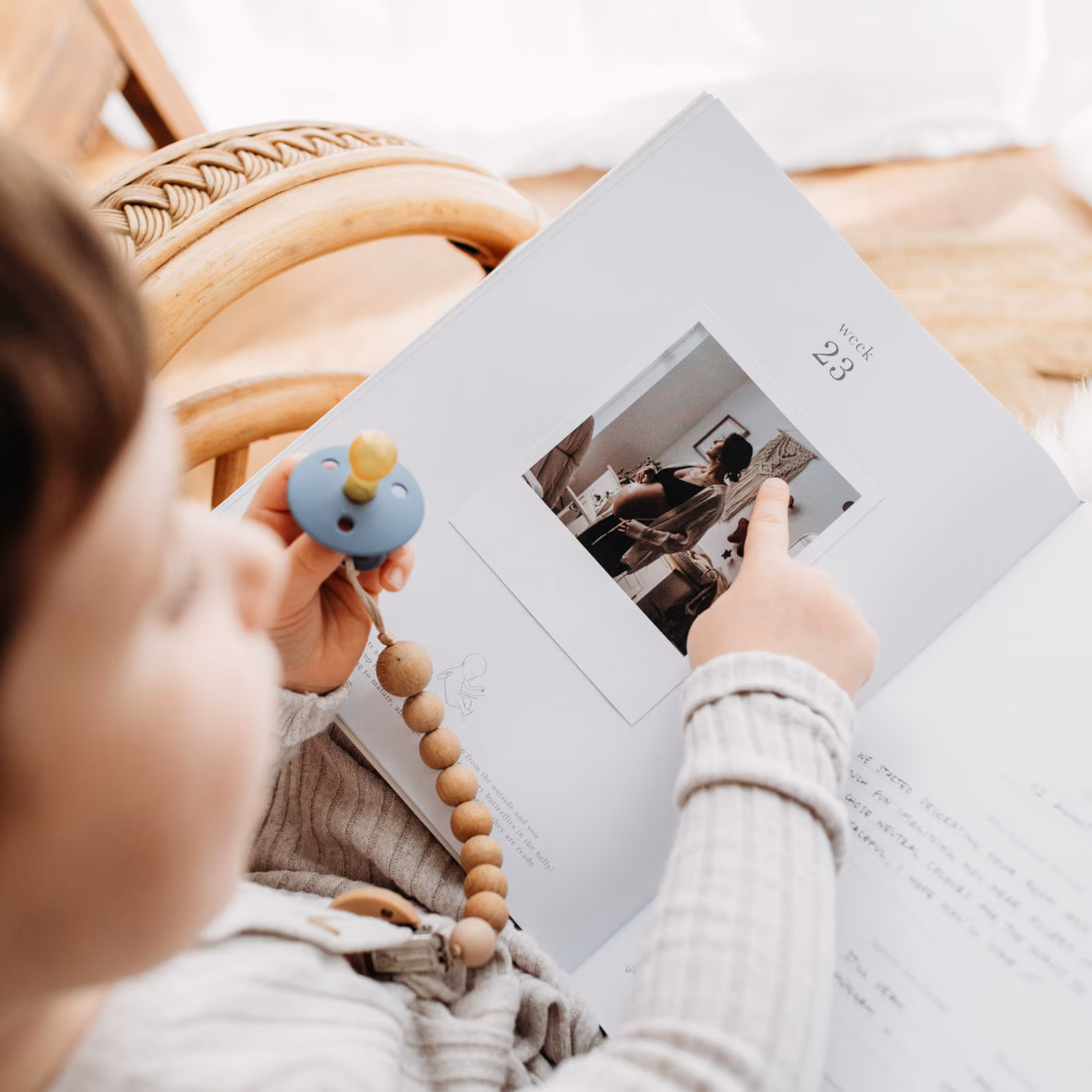 een kind wijst naar een zwangerschapsfoto in een dagboek voor zwangerschap en geboorte