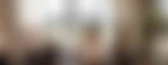 two pregnant woman on medicine balls looking out a window together chatting