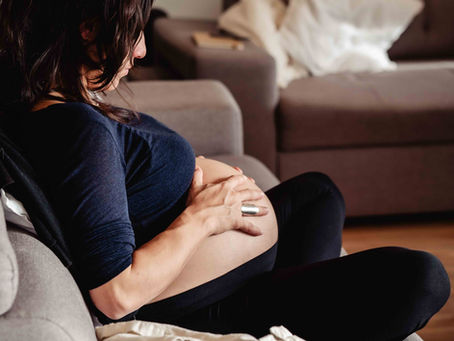 Close-up of hands on a pregnant belly during meditation