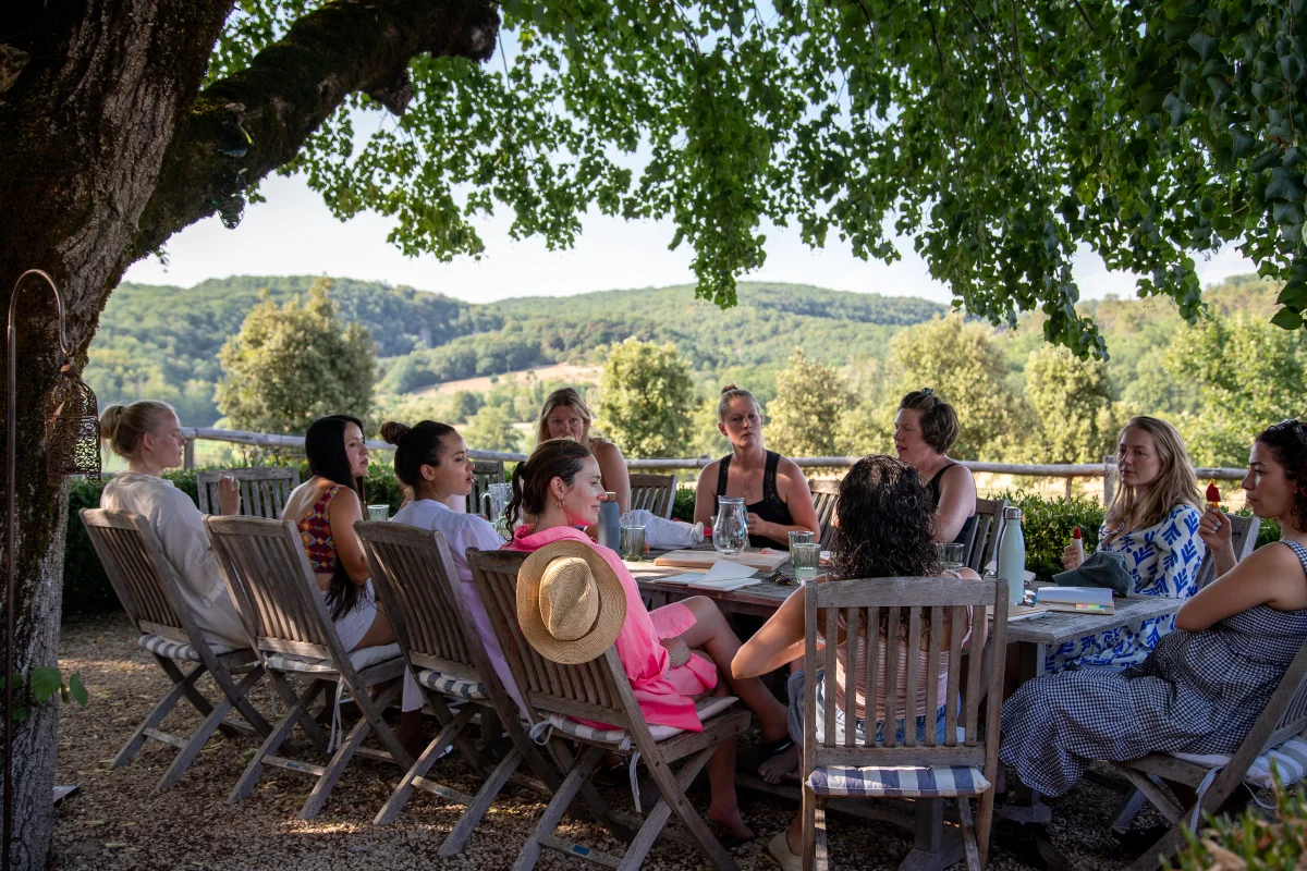 group of pregnant woman around a table chatting outise
