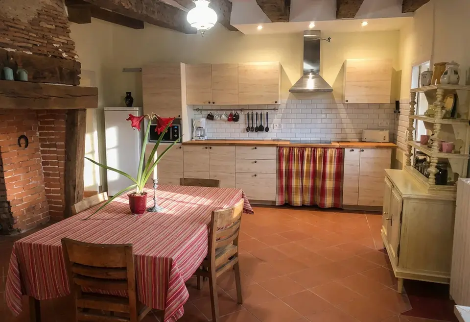 Shared Kitchen with dinner table and wood beam above
