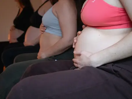Pregnant women holding their bellies during a pregnancy retreat in France