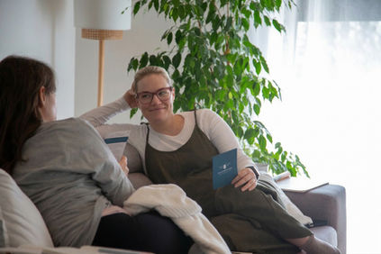 Pregnant woman getting to know each other, holding a hummingbee retreat question card
