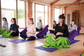 Small group of pregnant women enjoying a meditation and prenatal yoga session at The HummingBee retreat, a holistic wellness experiences.