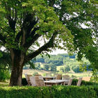 One of the outdoor dinning areas under a pergola looking over rolling hills