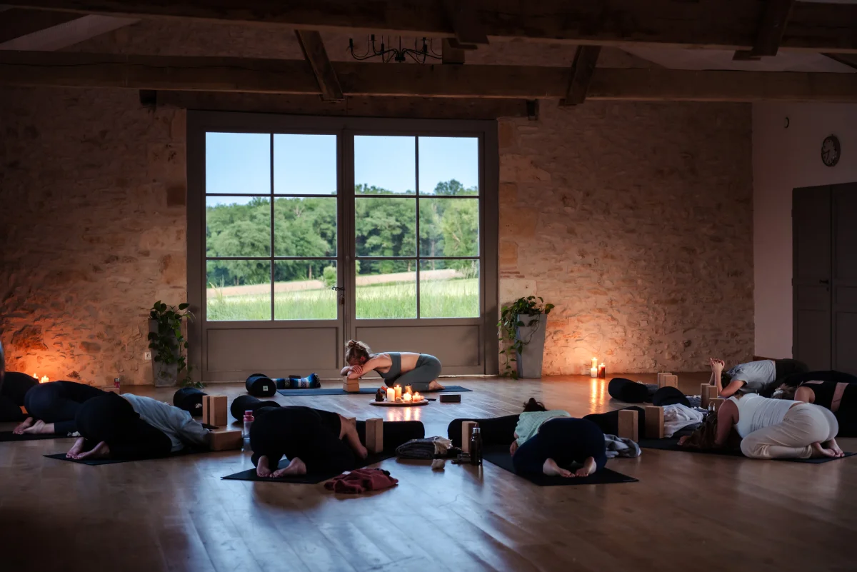 group of pregnant woman attending a prenatal yoga class at the hummingbee pregnancy retreat. big yoga room with candels