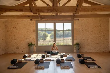 Yoga studio with teacher in the center of two big glass doors to the outside