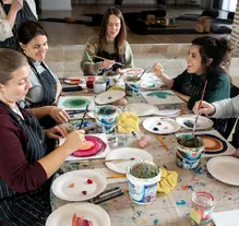 Painting workshop, pregnant woman painting around a table at the hummingbee retreat