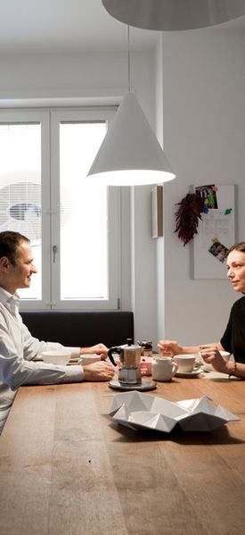 cucina in Corian e legno laccato, Bulthaup. Tavolo Bigfoot di Philipp Mainzer per E15, sedie in acciaio cromato di Harry Bertoia per Knoll. A sospensione lampade Diabolo di Achille Castiglioni per Flos.