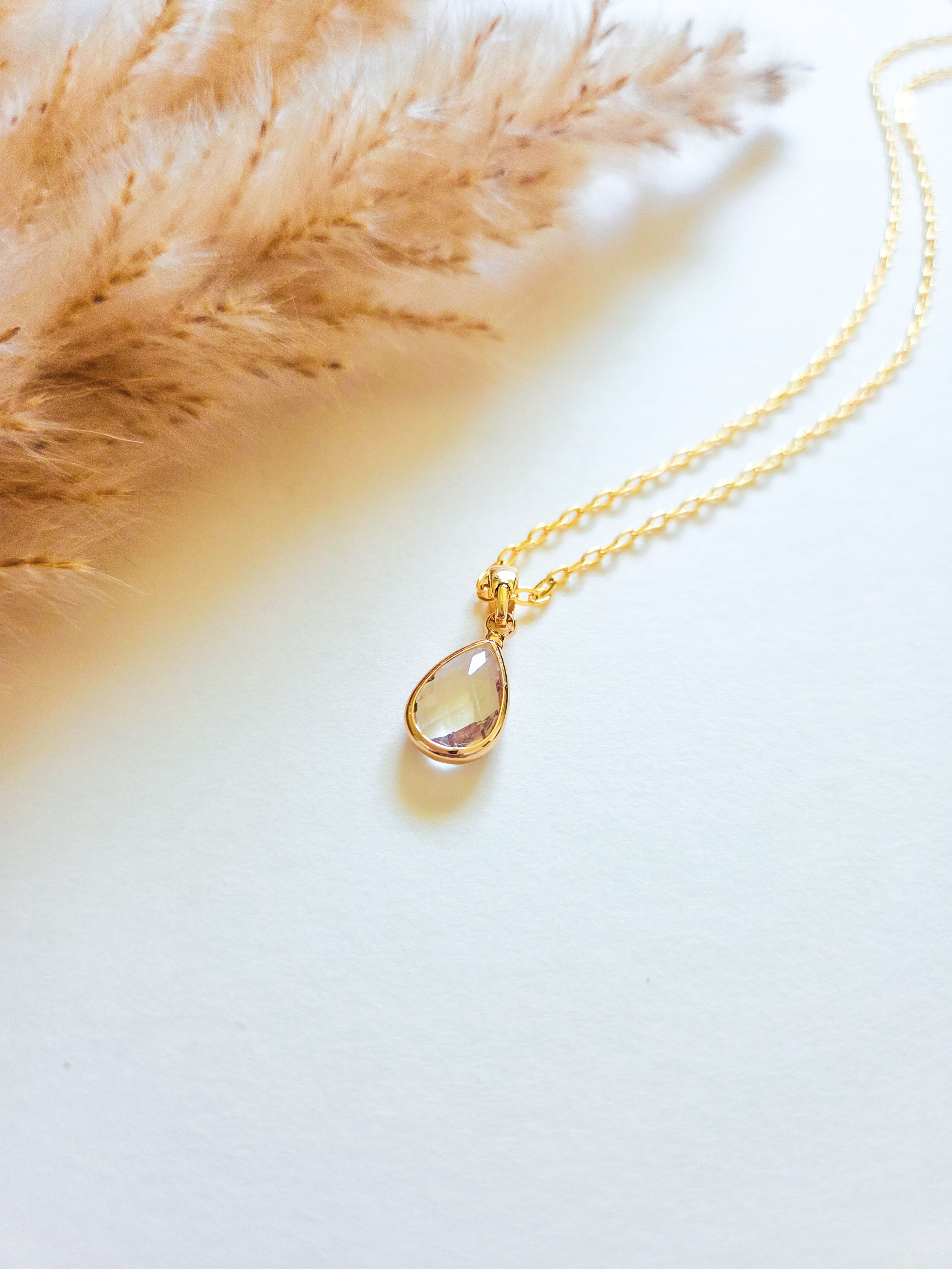 Teardrop crystal pendant necklace with gold chain.