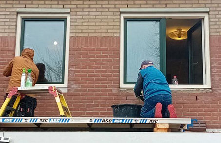 Plaatsing van twee nieuwe kunststof ramen op de eerste verdieping door monteurs