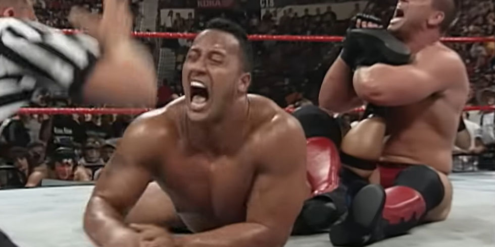 Ken Shamrock applying the ankle lock to The Rock during the 1998 WWF King of the Ring final