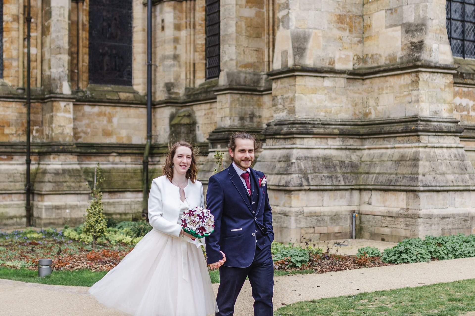 Bride and groom walking through the Dean's Gardens at Lincoln Cathedral Wedding 