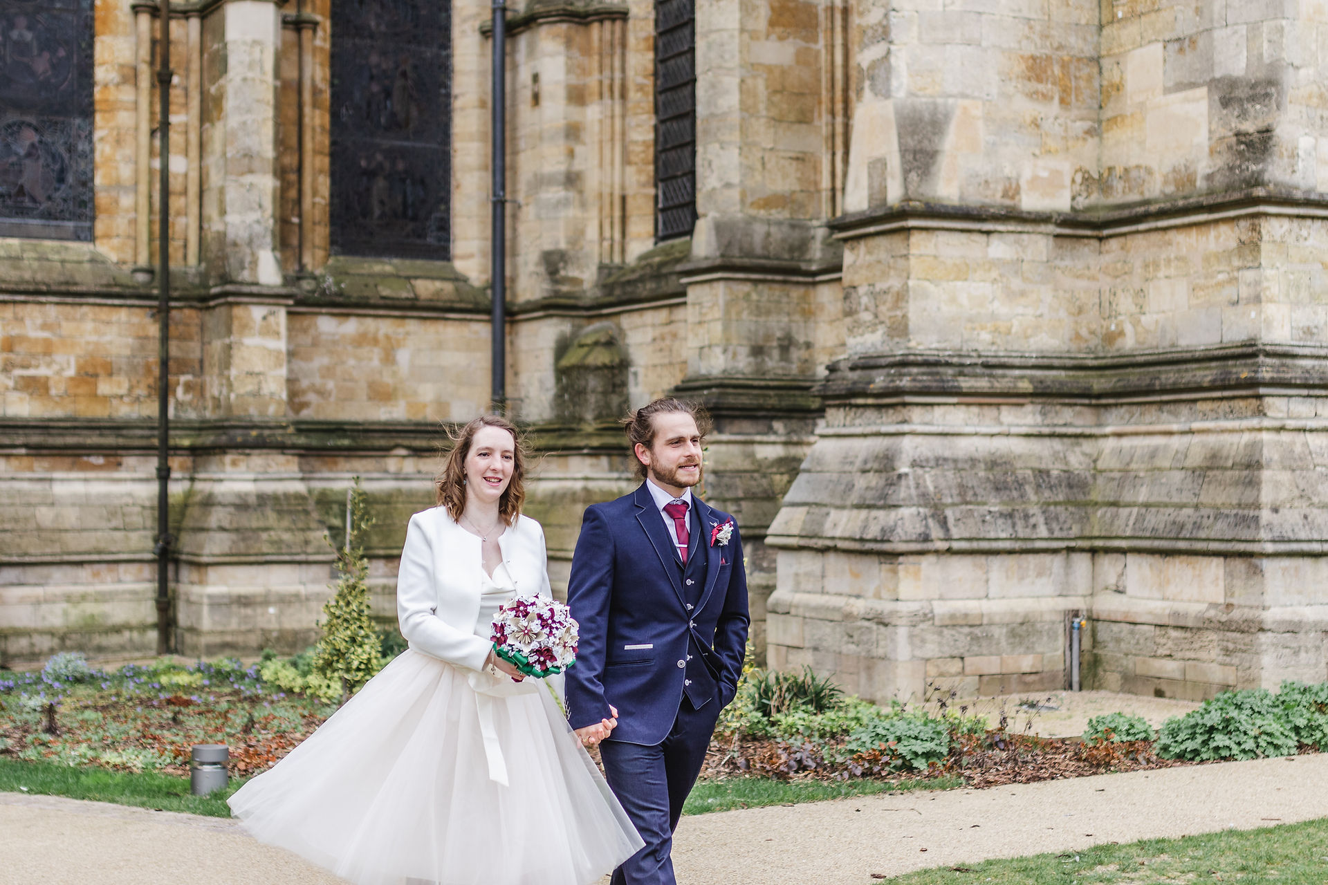 Bride and groom walking through the Dean's Gardens at Lincoln Cathedral Wedding