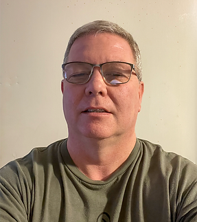 The imge shows Mike Miles, the Operations Director of the Hope Center Food and Resource Center, against a cream-colored wall.