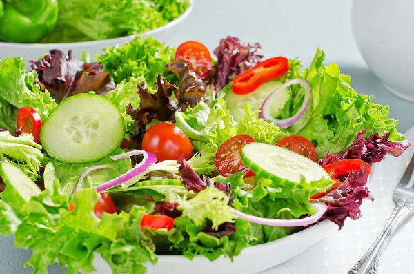 Đĩa salad rau xanh và trái cây tươi nhiều màu sắc giàu vitamin và khoáng chất.