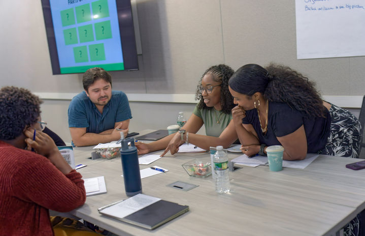 Graduate scholars collaborate during a group coaching session at a dissertation retreat.