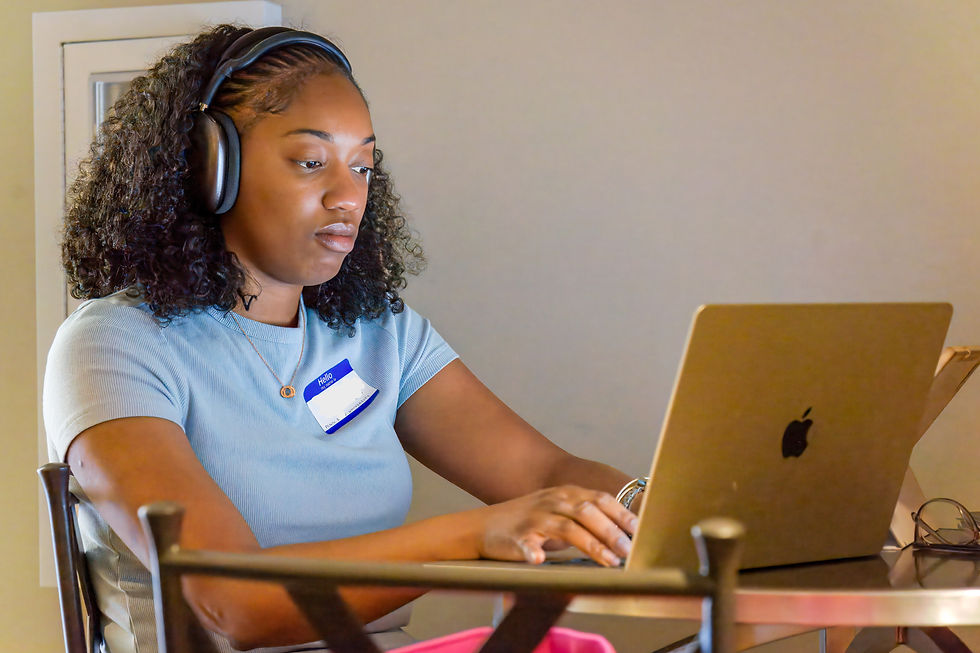 Academic writer wearing headphones works on a laptop during a focused writing session.