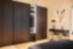 Slaapkamer met donker maatwerk-kast en minimalistisch dressoir