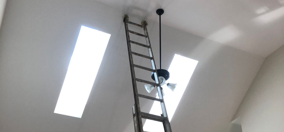 Ladder positioned beneath a vaulted ceiling during a light fixture installation project.