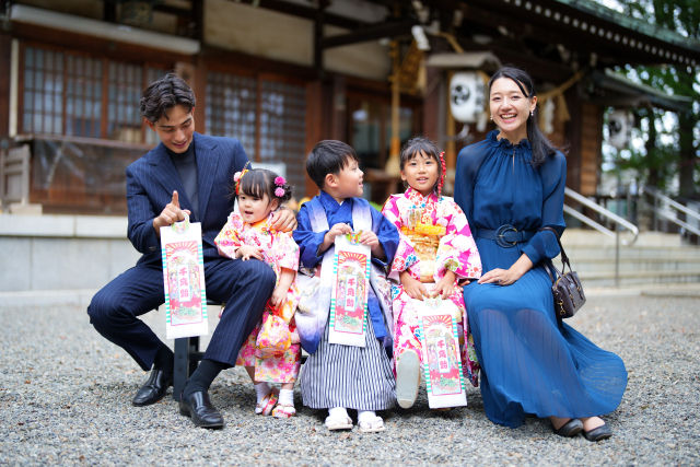 Family celebrating Shichi-Go-San with children in kimono at a shrine.