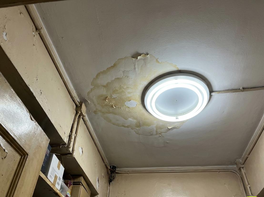 客廳天花嚴重滲水 - 大範圍黃啡色水漬環繞天花燈,批盪剝落見底層 - 恒昌工程專業滲水維修
