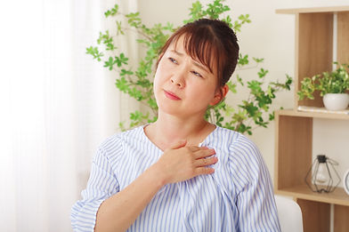 胸を押さえる女性