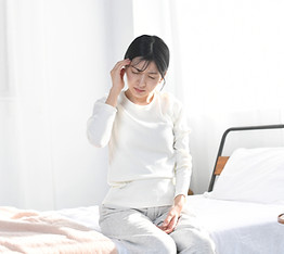 頭を押さえている女性