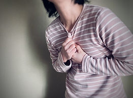 胸を抑える女性