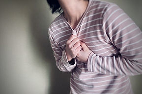 胸を抑える女性