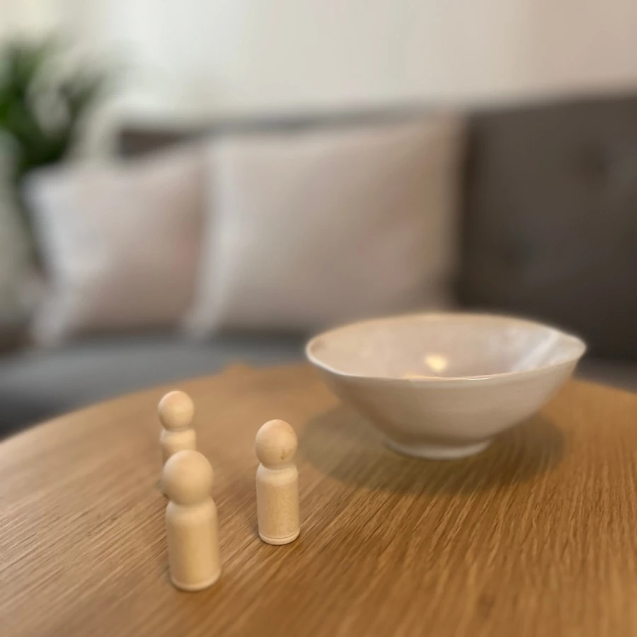 Coaching-Material für Aufstellungsübungen, um herausfordernden Situationen mit mentaler Klarheit begegnen zu können, auf einem Tisch in der Stressablage in Steyr. Im Hintergrund das bequeme Coaching-Sofa.