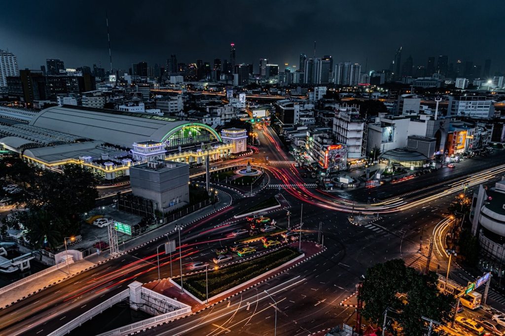 Night skyline of Bangkok with a view of a busy highway and illuminated buildings.