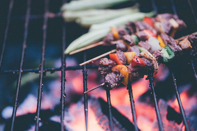 Vietnamese barbecue skewers cooking over an open flame.