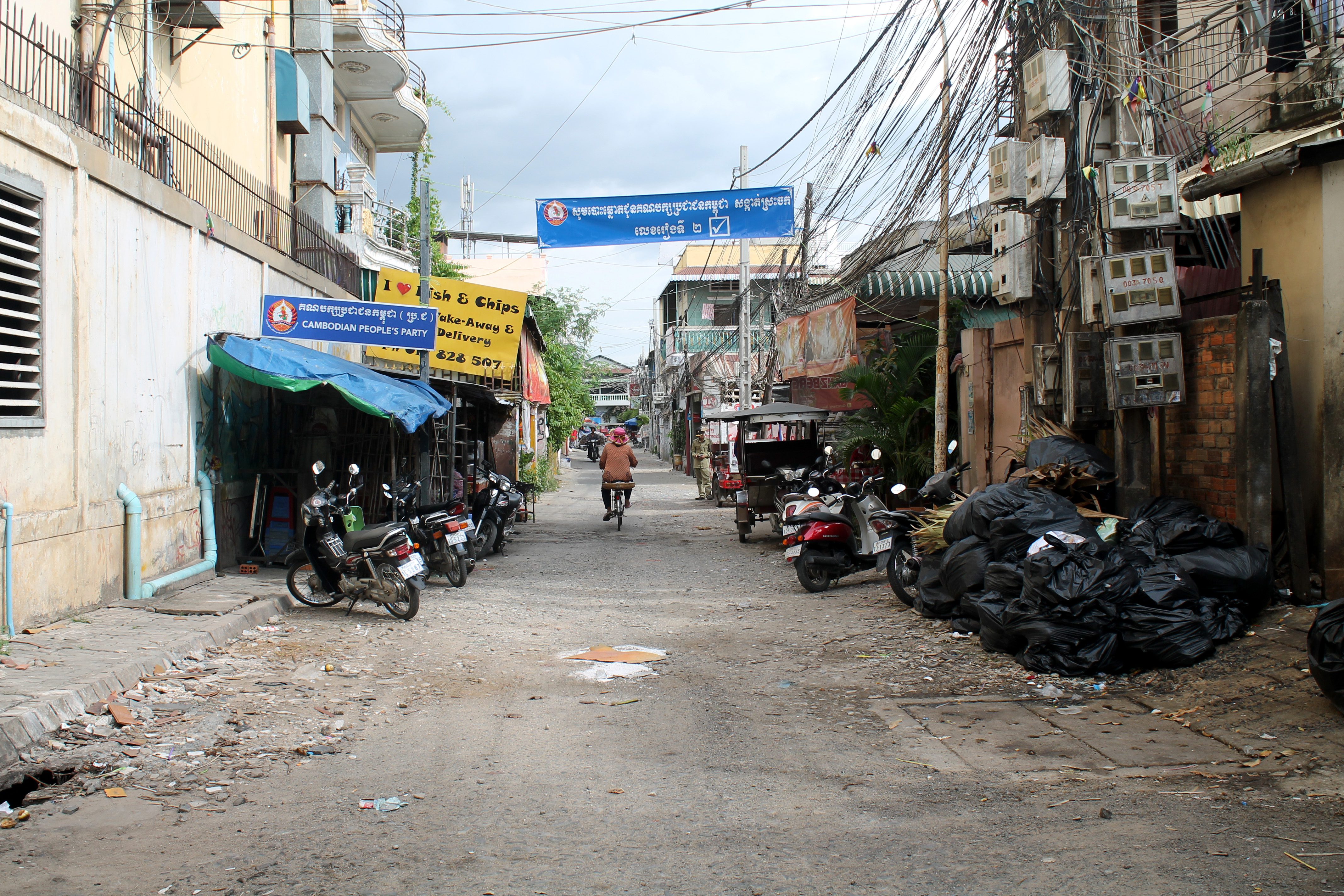 A narrow street in Boeung Kak with colorful murals and local businesses.