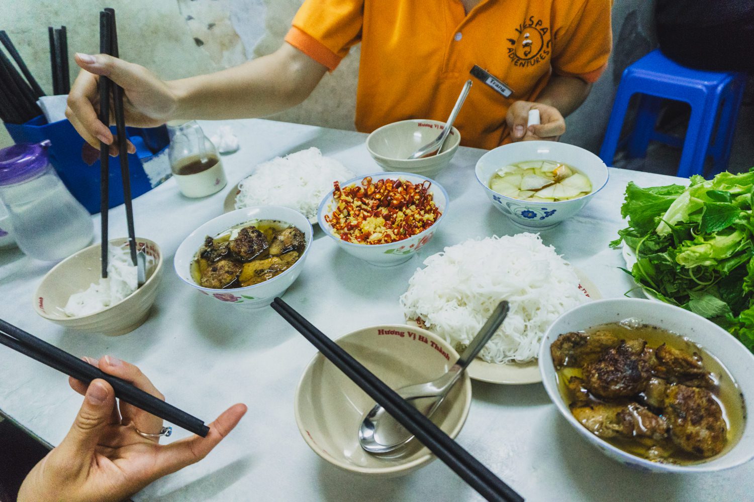 A steaming bowl of bun cha, served with rice noodles and fresh herbs.