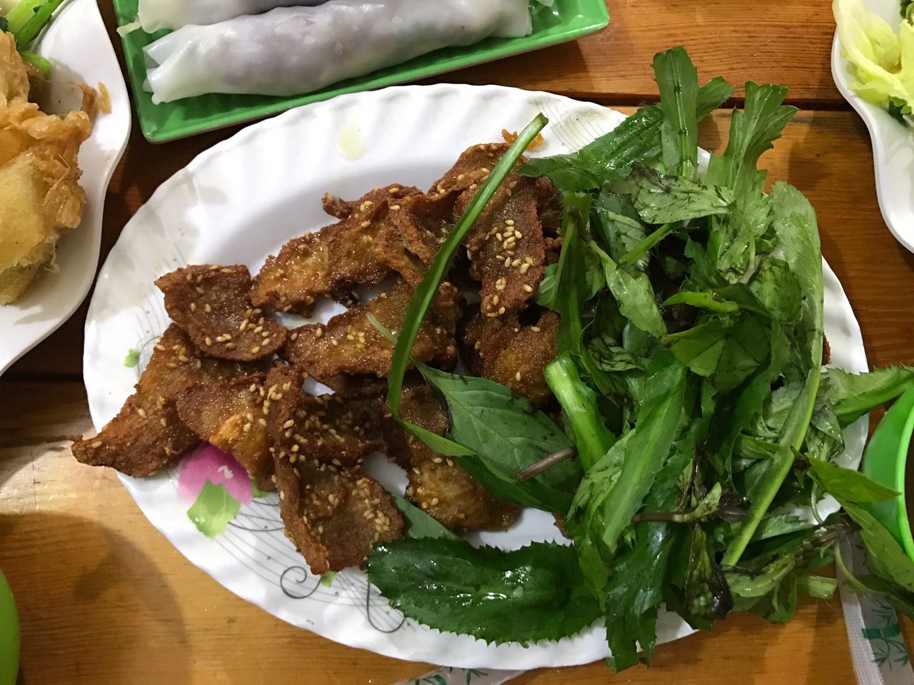 A plate of Pho Cuon, fresh Vietnamese noodle rolls stuffed with beef and herbs.